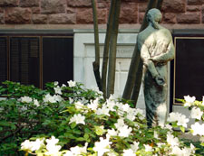 Statue of Jesus Christ in a memorial garden with white azaleas.
